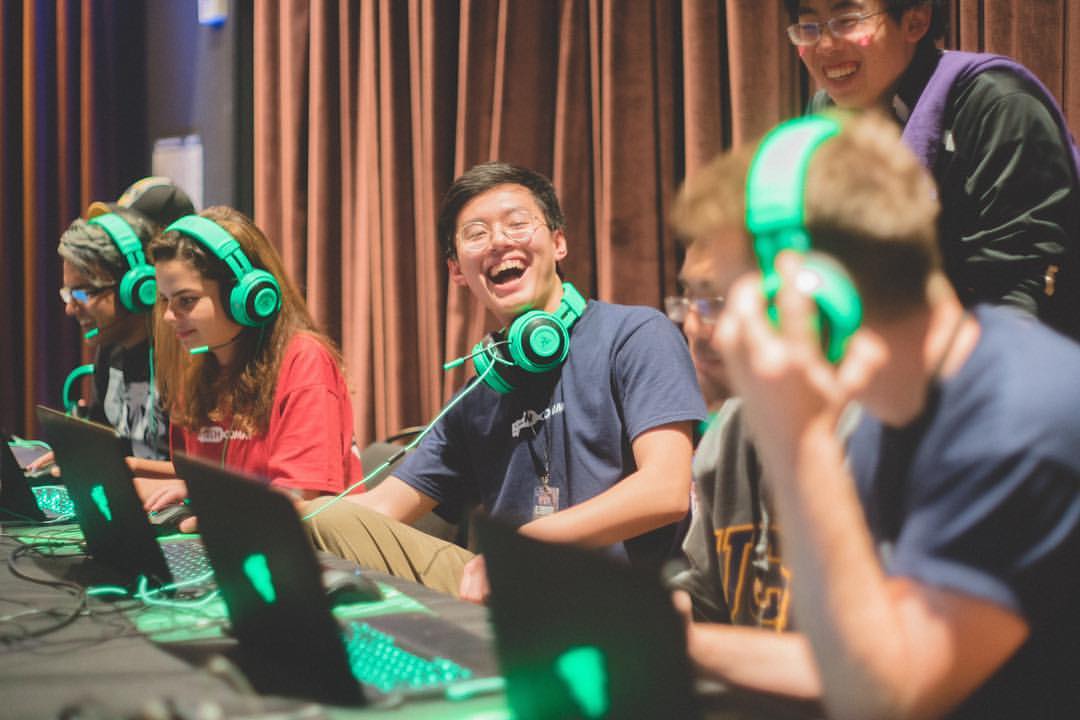 Students laughing while playing games on a computer